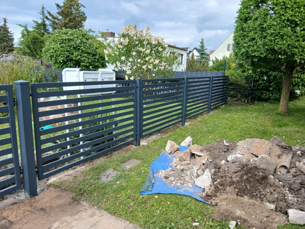 Moderner Lamellenzaun aus Metall mit Tor
